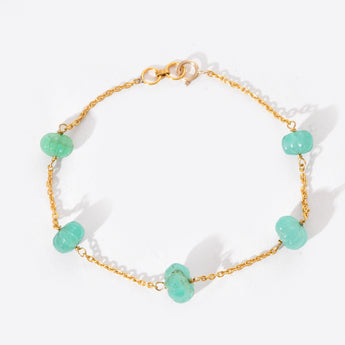 Bracelet with gold chain and turquoise beads on a white background