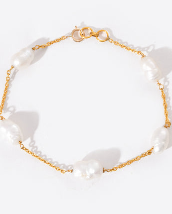 Pearl bracelet with gold chain on a white background