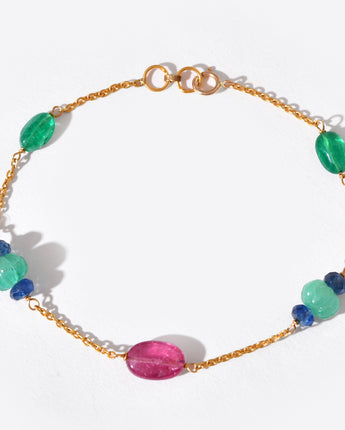 Gold bracelet with colorful beads on a white background