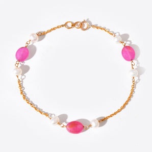 Bracelet with pink gemstones and gold chain on a white background
