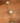 Close-up of a gold chain bracelet with pearls and green beads on a wrist.