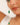 Close-up of a bracelet with green and white beads on a blurred background