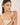 Woman wearing a beige tank top against a plain background
