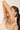 Woman showing her wrist bracelet against a plain background