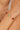 Bracelet with red and green beads on a wrist against a neutral background
