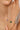 Close-up of a hand wearing a delicate bracelet with colorful beads on a neutral background