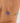 Gold bracelet with a blue and green bead on a wrist against a neutral background