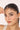 Woman holding a delicate bracelet to her face with a white background