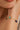 Gold bracelet with green and blue beads on a wrist