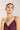 Woman wearing a necklace with a plain background