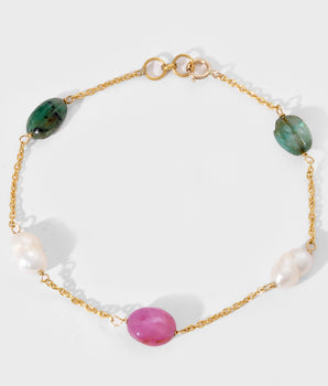 Bracelet with gold chain, green, pink, and white gemstone on a white background