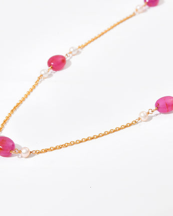 Necklace with pink beads and gold chain on a white background