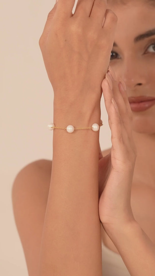Women showing is hand, wearing a beautiful white pearl bracelet.